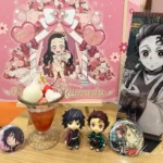 12月28日は炭治郎の妹、禰豆子ちゃんのお誕生日！ というわけで、ufotablecafeの禰豆子ちゃんのバースデーイベントに行ってきました。 カフェの飲食利用では、バースデーデザートのパフェが楽しめるほか、誕生祭の華やかな祭壇も各店に設けられておりワクワクする空間でお誕生日をお祝いすることが出来ます。 今回期間中に名古屋店と大阪店に遊びに行ったので、各店舗のバースデースタンプや祭壇もご紹介しますね。 禰豆子ちゃんの誕生祭2025 12月28日はねずこちゃんのお誕生日ということで、ufotablecafeでは12月28日からねずこちゃんのバースデーイベントが始まりました。 開催期間は2025年12月28日(日)～2026年2月1日(日)まで（ufotable Cafe Kitakyushu × マチ★アソビCAFE北九州、ufotable DINING各店、ufotable Cafe TO GO、ufotable CINEMAは2026年2月2日(月)まで）となっており、約1か月間バースデーイベントを楽しむことが出来ます。 12月28日はちょうど名古屋のミッドランドスクエアシネマで開催された鬼滅の刃無限城編の応援上映に参加していたのですが、お誕生日当日ということもありお祝いの声が多数上がり、劇場内がお祝いムードでとても盛り上がったのが印象的でした。 [st-card myclass="" id="1417" label="" pc_height="" name="" bgcolor="" color="" webicon="" readmore="on" thumbnail="on" type=""] 私は残念ながら当日のカフェには当選できず、年明けの1月6日に1回目のお祝いをさせていただきました！ バースデーデザートとランチョンマット バースデーのデザートは見た目も可愛らしいパフェ（税込み1200円）でした。 下はピーチゼリー、上に白玉団子やキラキラが載った雪見だいふく、さくらんぼ、砕いたピスタチオを散らしたホイップクリームなどが載った豪華なパフェです。 一番下がゼリーなので他のメニューの後でも食べやすく、ハートのマシュマロ、雪見だいふくや白玉、ホイップクリームもたっぷり載っているので食べ応えもあるパフェでした。 美味しくて結局期間中に2回注文してしまいました。 初めて注文した時は、お祝い用にねずこちゃんのグッズも色々持って行きました。 グッズを飾って楽しめるのもコラボカフェならではで楽しいですよね。 パフェを注文すると、奥に飾っている可愛いA3サイズのランチョンマットがノベルティとしてもらえます。 ランチョンマットは紙製なので、そのまま使うと汚れてしまうため私はA3サイズのファイルに入れて収納するか、気に入ったものは無印良品のアクリルフレームに入れて壁にかけて飾っています。 このねずこちゃんはアイドルみたいで本当に可愛くて癒されました。 祭壇も可愛い！ バースデーイベントの期間はカフェの中に各キャラクターごとの誕生祭の祭壇が設けられるのですが、ねずこちゃんはピンク尽くしでとても可愛い祭壇になっていました。 名古屋店 まずこちらが「ufotable Cafe Nagoya×マチ★アソビCAFE NAGOYA」の祭壇です。 ファンの方からのお手紙も多く飾ってあり、見ごたえがある祭壇になっていました。 名古屋は毎回お花で作った各キャラのくまが居ますよね。 大阪店 続いてこちらが「ufotable Cafe Osaka / マチ★アソビCAFE大阪」の祭壇です。 ちょうど期間中に遠征できたので、撮影させていただきました！ 大阪は名古屋に比べてなんだかおしゃれな祭壇で雰囲気があり素敵でした。 [st-card myclass="" id="1528" label="" pc_height="" name="" bgcolor="" color="" webicon="" readmore="on" thumbnail="on" type=""] 大阪店はこの時初めて行ったのですが、祭壇もお店によって結構カラーが違うんだなぁと比べてみて面白かったです。 バースデースタンプ 期間中は各店舗やTogoにもバースデースタンプ台に各キャラクターのバースデースタンプが登場します。 各店舗によって絵柄が異なるので、タックシールに押して集めている方も多いですよね。 私は自分が遊びに行ったお店のスタンプだけ集めているので、店頭で販売しているバースデースタンプ用のノートに押しています。 名古屋店 名古屋はこんな感じでした。 インクもたっぷりでキレイに押せました！ 大阪店 大阪の絵柄はこちら。 ちょうどインクが切れていたのか、私が下手なのか少しかすれてしまい悲しい感じになっていますが可愛いです。 今回バースデーのグッズは購入しませんでしたが、少しくすんだようなピンク色が可愛くてロゼッタやトートバッグは色持ちしても可愛いなぁと思いました。 デザートも各キャラクターごとにメニューが異なるので毎回楽しみですね。 以上「禰豆子ちゃんの誕生祭2025」のご紹介でした。